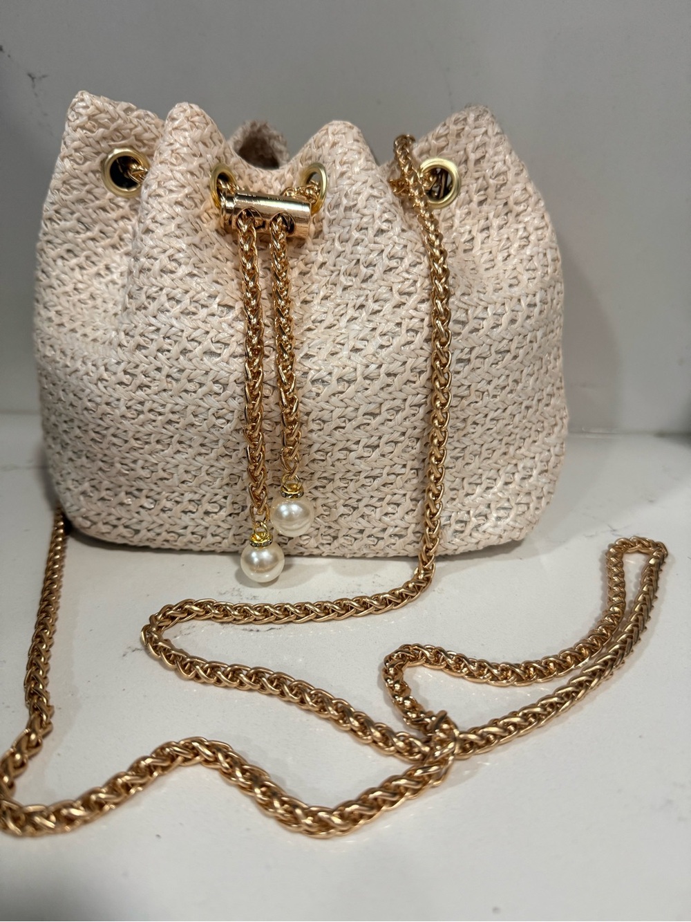 Cream Woven Drawstring Bucket Bag with Gold Chain and Pearl Accents